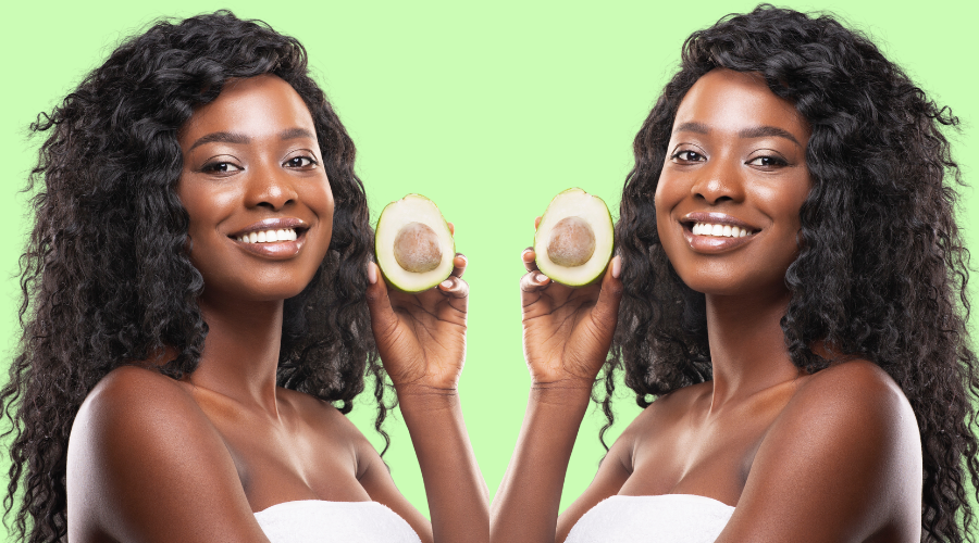 Woman holding a fresh avocado, symbolizing the potential benefits of avocado hair oil for hair care.