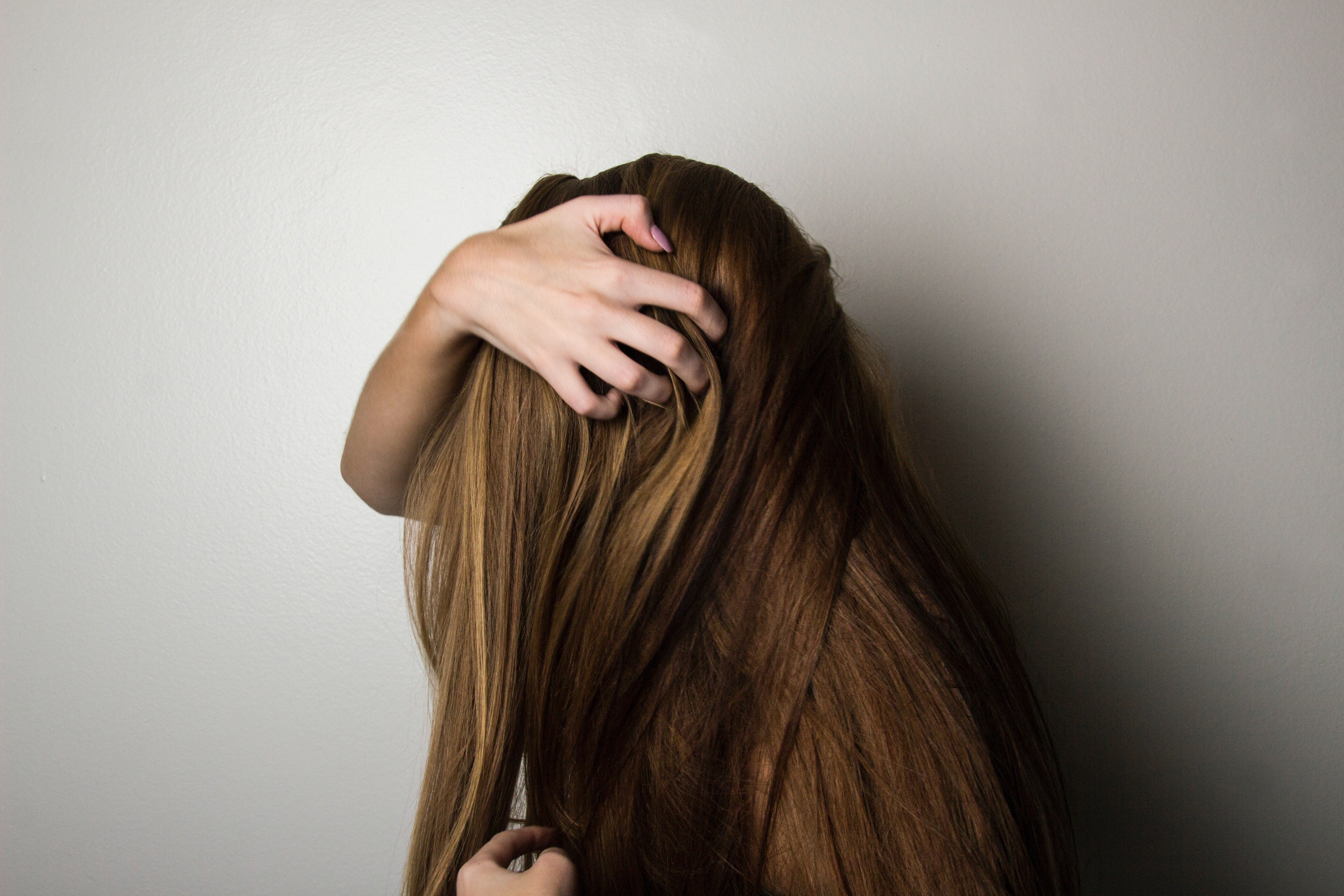 Picture of a woman trying to detangle her hair.