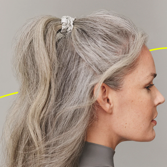 woman with grey hair wearing two hair scrunchies to protect her hair