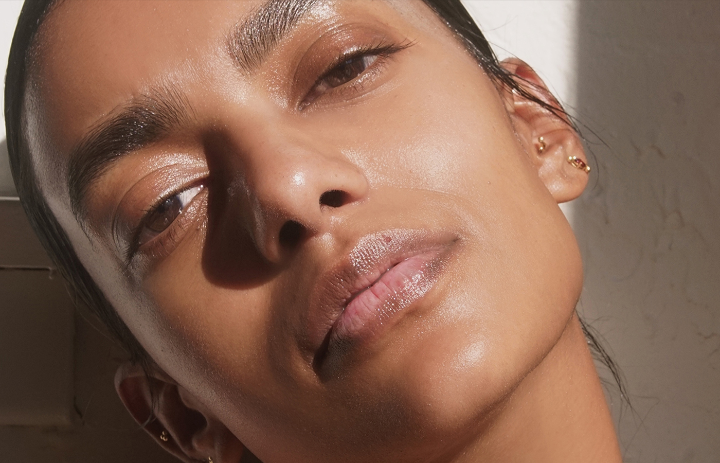 woman standing in the sunlight with balanced skin microbiome. Landscape image with white and brown tones.