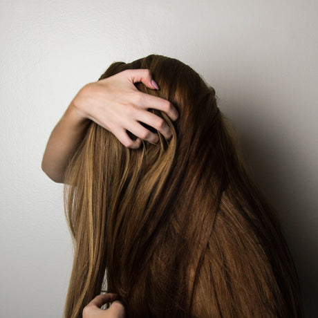 Picture of a woman trying to detangle her hair.
