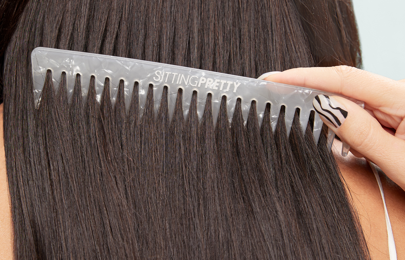 In this blog post, we will guide you on how to brush your hair properly to prevent damage. The accompanying image shows a woman delicately brushing her wet hair. Brushing wet hair requires extra caution as it is more vulnerable to breakage.