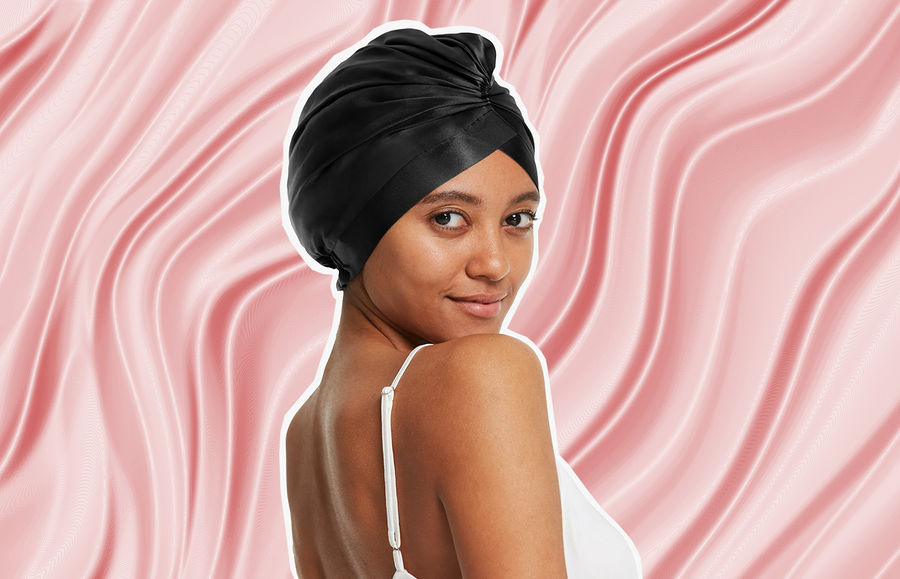 black woman wearing a silk hair cap for sleeping in black silk colourway