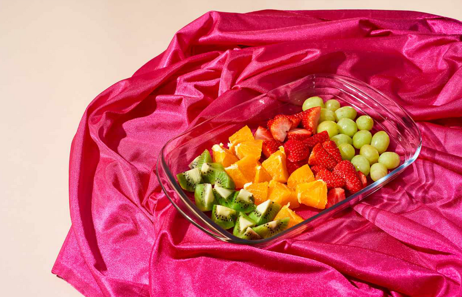 laying on a pink blanket, bowl full of fruits that are part of a diet for healthy, glowing skin bowl