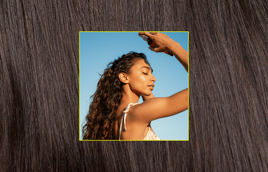 woman with curls spraying hair texture spray onto her scalp