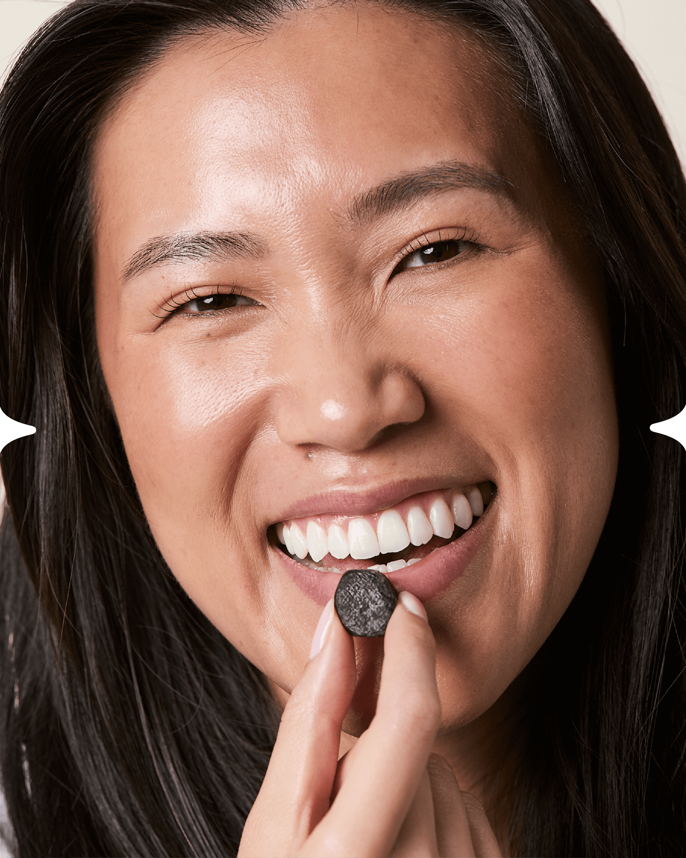 Woman smiling while taking a hair health nutraceutical gummy
