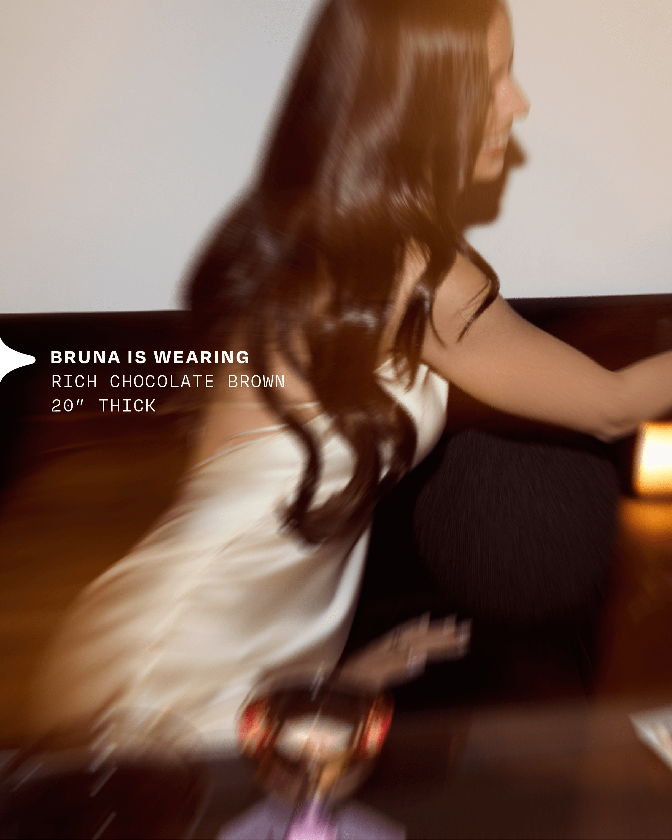A woman in a satin dress flips her hair and long halo hair extension while out for drinks 