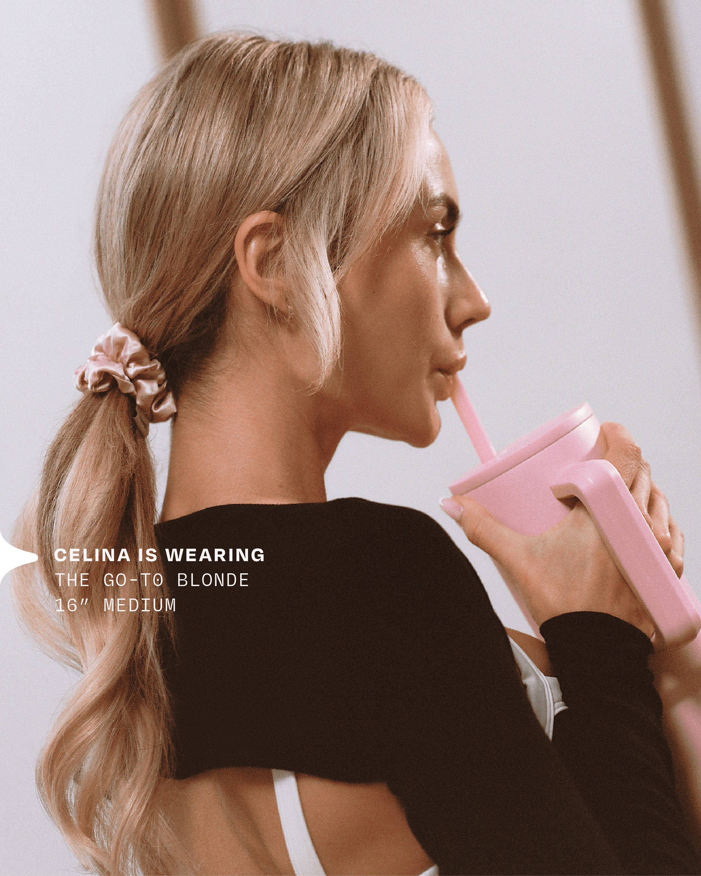 A woman wears her halo hair extension in a ponytail while sipping water during a workout